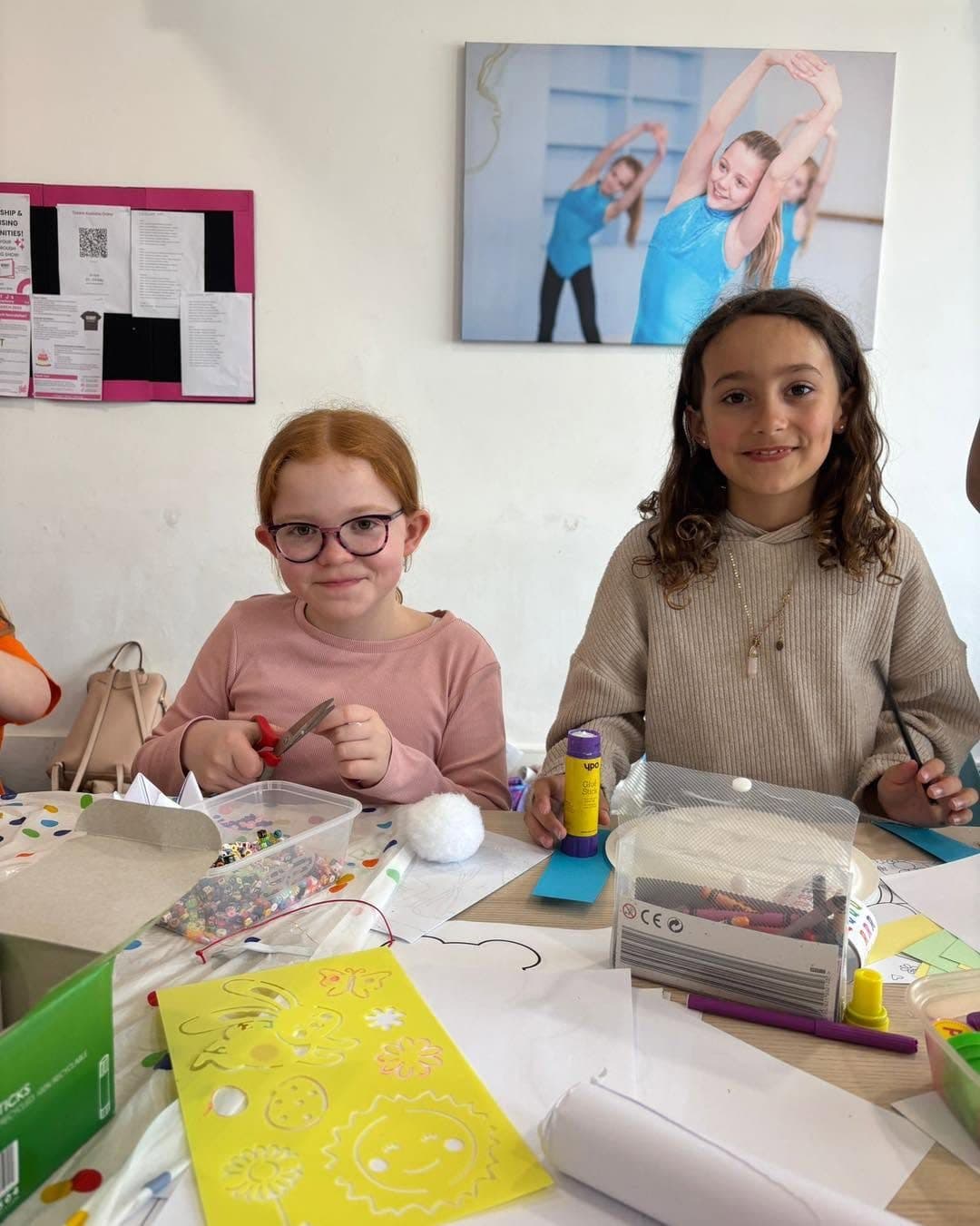 Two girls smiling at a craft table during a Jazzy J's camp