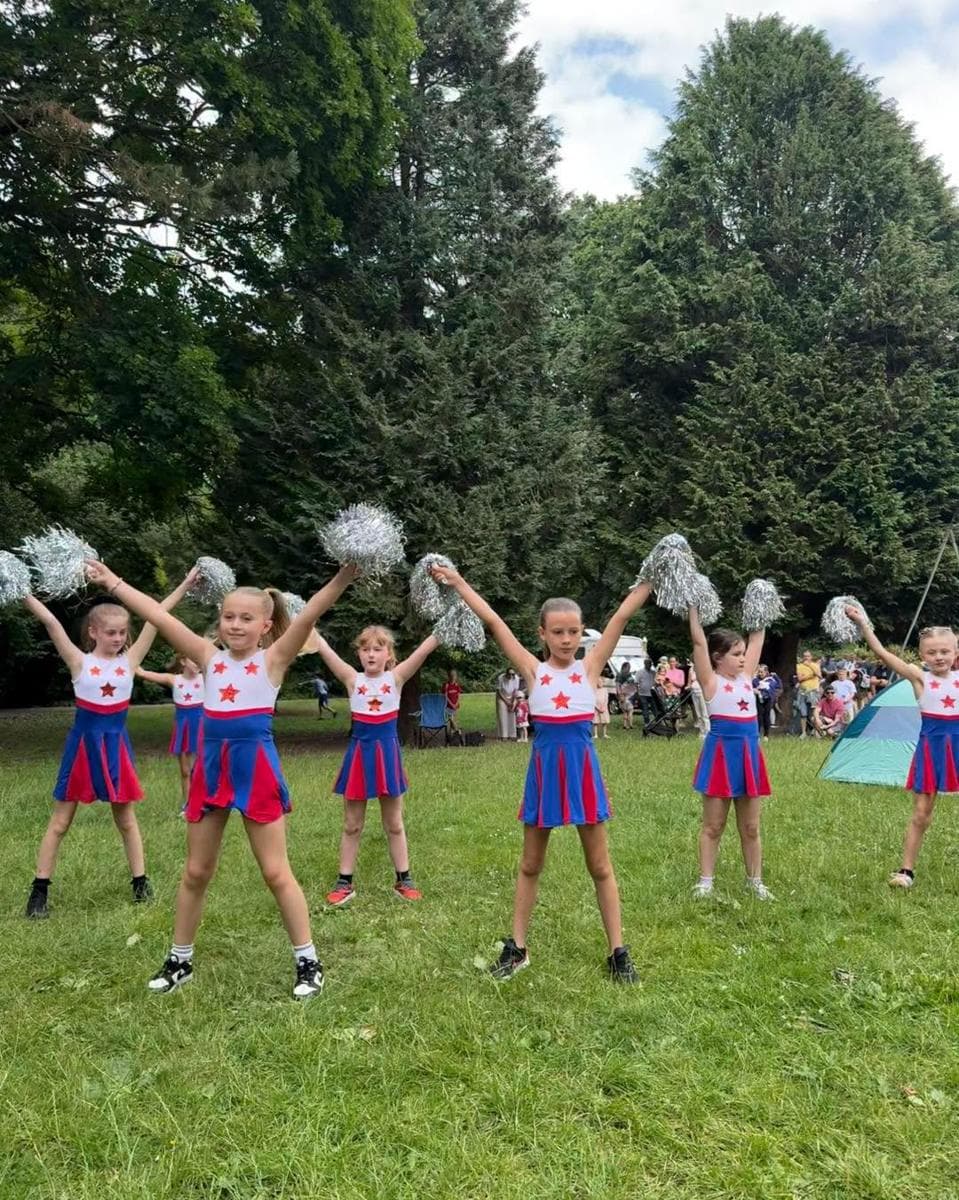 Campers performing a pom-pom routine in the park